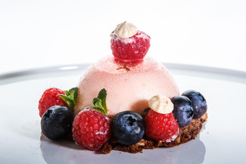 delicious pink dessert covered with fresh raspberries and blueberries