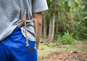 The boy with a slingshot in shorts.