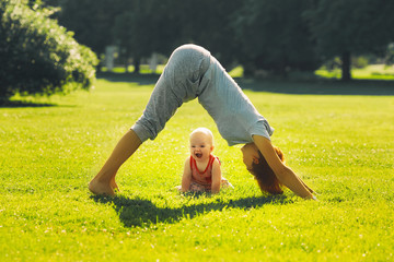 Woman doing yoga with baby in nature