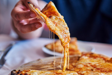 Hot pizza slice with melting cheese.  Lunch or dinner  delicious food italian traditional on wooden...