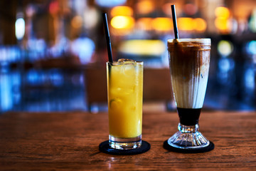 Ice coffee and orange juice on the table.