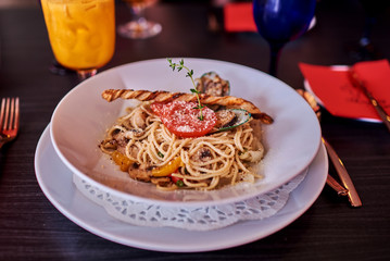 Spaghetti with sauce in the dish on the dark table.