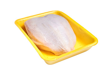 Raw and uncooked chicken breast with skin in a yellow plastic container. Meat of poultry in tray, isolated on white background