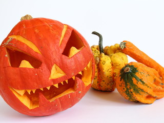 Wystrój wnętrza na halloween - zdobiona, pomarańczowa dynia i kolorowe dynie ozdobne