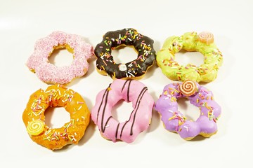 Multi-colored donuts on a white background.