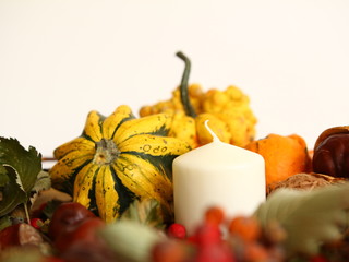 Żółta i pomarańczowa dynia ozdobna z jarzębiną i białą świecą - stylowa dekoracja na stół do każdego wnętrza - jesienna ozdoba na halloween na białym tle