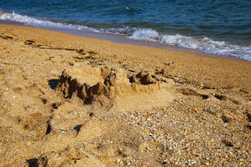 Castle in the sand against the sea.