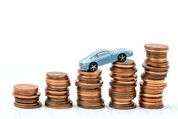 Mini car model on stack of coins