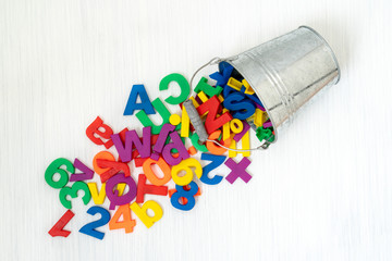 Numbers and letters falling from bucket