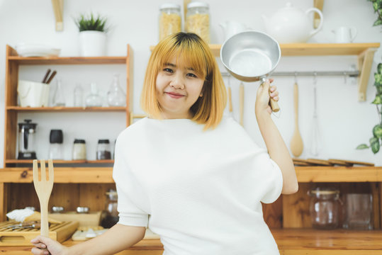 Asian woman making healthy food standing happy smiling in kitchen preparing salad. Beautiful cheerful Asian young woman at home. Healthy food dieting and healthy lifestyle cooking at home Concept.