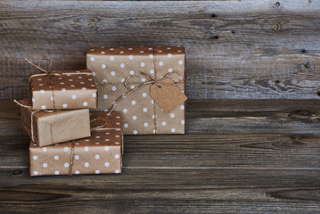Handmade gift boxes wrapped with eco friendly craft paper and tied with twine on wooden vintage background. Background for your design. Holiday packing concept. Copy space for text. .