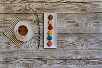 Morning cup of coffee, macaroons  and flower on white table from above. Beautiful breakfast. Top view.