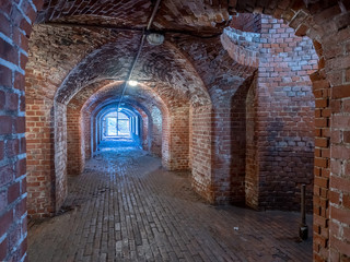Kaliningrad, Russia - May, 2018. Brick underground tunnel or corridor and light in the end