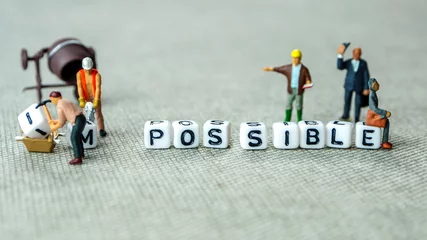 Foto op Plexiglas Removing white cubes with letters i and m of the word impossible creating new word possible on grey background with miniature figurines © jan_S