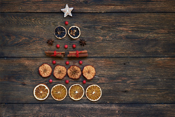 Christmas tree made from anise star seeds, cinnamon sticks, orange dry, dry lemon and dry apple with copy space background.