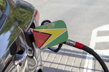 Fueling car with petrol pump at a gas station.