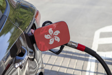 Fueling car with petrol pump at a gas station.