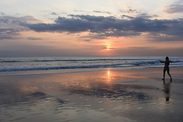 Black silhouette  happy carefree woman walking at sunset on the beach. Happy free lifestyle concept.  Abstract background.