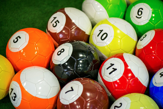 Shot of foot pool balls standing on green table. Foot Pool is the hybrid combination of pool and soccer. Big billiard balls. 
