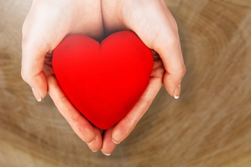 Hands of young woman holding red heart