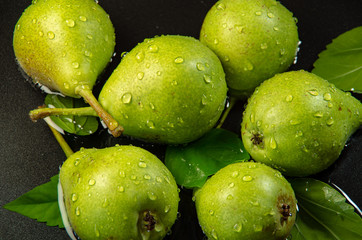 Green pears are splashed with drops of water