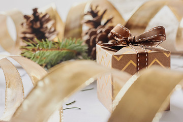 Christmas and New Year holidays concept. Gift boxes with ribbon, fir branch, cones on white knitted background