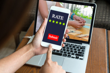 Hand pressing the show Rate submit with five star button over hand tying a rope the prepaing package the product with office equipment online shopping, entrepreneur business concept