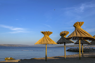 Nice view of beach Croatia. Crystal clear waters and beach umbrellas . Island Krk.