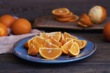 Fresh oranges on ceramic plate on vintage background. Vintage still life with oranges.