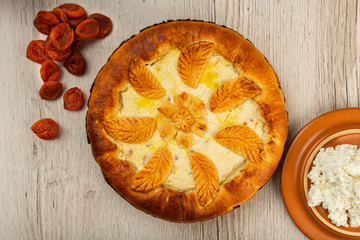 Home-made curd cake on a wooden background with ingredients.