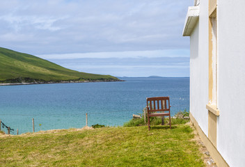 One old wooden chair in a garden facing beautiful sea views. Taken on Achill Island, Ireland.