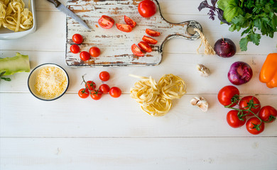 Balanced diet, cooking, culinary and food concept. Healthy food. Close up of fresh vegetables, pasta, cheese parmesan and spices on rustic wooden table. Rustic ctyle. View from above with copy space.