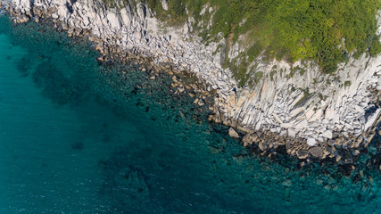 Aerial drone top view of rocky coast line on sunny summer day