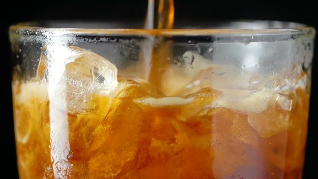 4K Slow motion pouring cola soda rootbeer mixed water in to the glass with ice