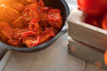 Traditional Italian cooking. Bowl of homemade sun dried tomatoes with olive oil and herbs on wooden background. Healthy food. Natural nutrition. Organic vegetables. Top view. Selective focus.