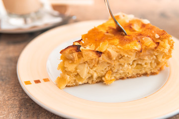 Apple cake on orange plate with glace on top