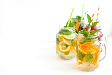 Homemade iced lemonade with mint, summer fruits and berries in a mason jar. Copy space background