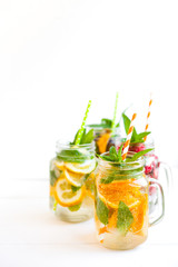 Fototapeta na wymiar Homemade iced lemonade with mint, summer fruits and berries in a mason jar. Copy space background