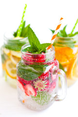 Homemade iced lemonade with mint, summer fruits and berries in a mason jar. Copy space background