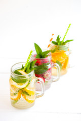 Homemade iced lemonade with mint, summer fruits and berries in a mason jar. Copy space background