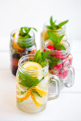 Homemade iced lemonade with mint, summer fruits and berries in a mason jar. Copy space background