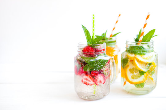 Homemade iced lemonade with mint, summer fruits and berries in a mason jar. Copy space background