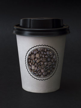 paper cup with coffee on a black background. 