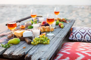 Crédence de cuisine en verre imprimé Pique-nique Picnic on beach at sunset in boho style. Romantic dinner, friends party, summertime, food and drink concept