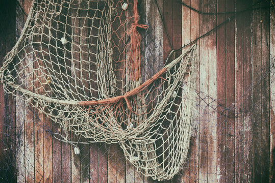 Hanging fishnet on wood wall. Background and texture for text or image.  Stock Photo