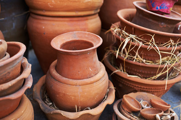 Handmade ceramic vases. Clay pots stacked for sale. Pottery making place. Local craft market. Craftsmanship. Traditional clay pottery. Shop of pottery. Various ceramic pots stacked  for sale.