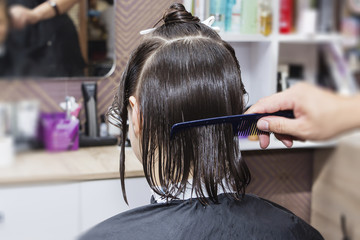 Fototapeta premium stylist hairdresser in barber shop doing haircut closeup.