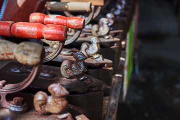 Vintage irons. Various vintage objects for sale at a indoor flea market. View of a display full of interesting old things for sale. Many groups of vintage assorted second-hand objects.