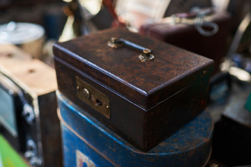 Old suitcase. Various vintage objects for sale at a indoor flea market. View of a display full of interesting old things for sale. Many groups of vintage assorted second-hand objects.