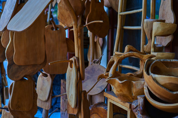 Fototapeta na wymiar Wooden cutting boards from natural wood in the market. Handmade souvenirs. Craft eco product of untreated wood for sale. Wooden crafts on a stall in the market. Walnut handmade wood cutting board.